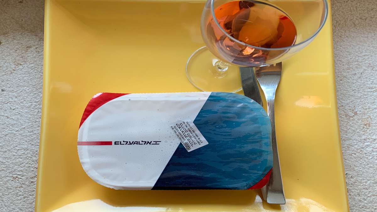 φαγητό αεροπλάνου σε δίσκο με ποτήρι κρασί