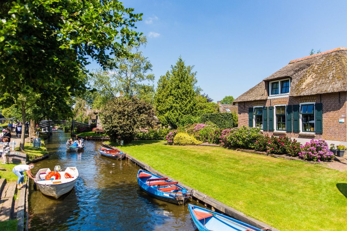 Giethoorn χωριό Ολλανδίας σπίτι σε ποτάμι με βάρκες για τους τουρίστες