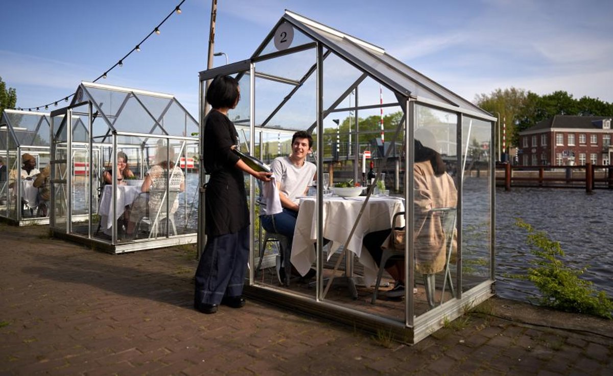 Εστιατόρια χειμώνας Mediamatic Αμστερνταμ με σπιτάκια και πελάτες με σερβιτόρο