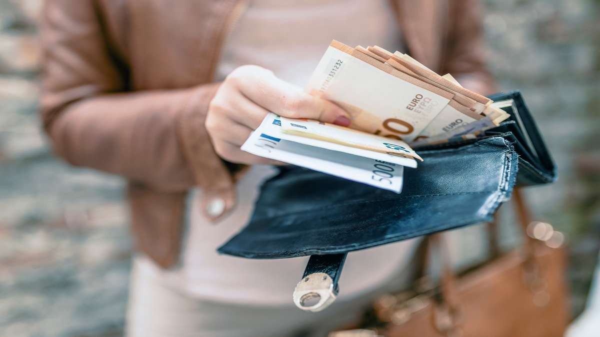γυναίκα κρατάει χρήματα πορτοφόλι