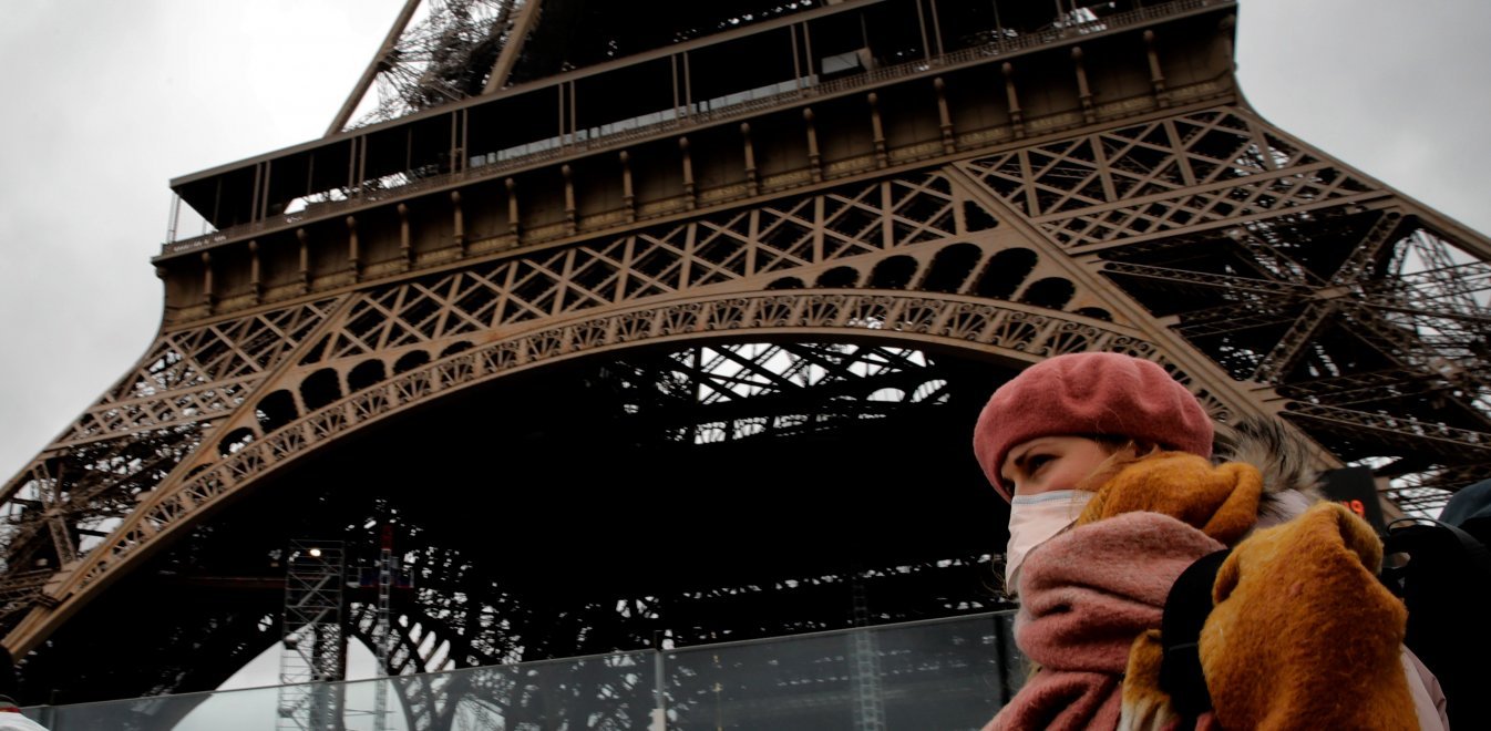 Κορονοίός Γαλλία Παρίσι κάτοικος με μάσκα μπροστά στο Πύργο του Άιφελ